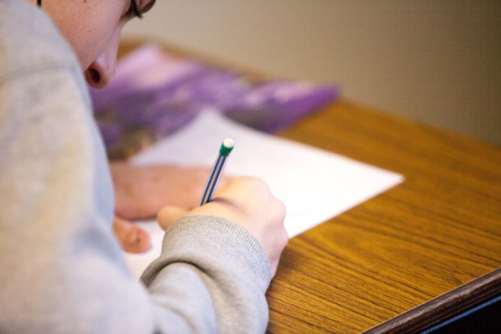 Person writing on paper worksheets