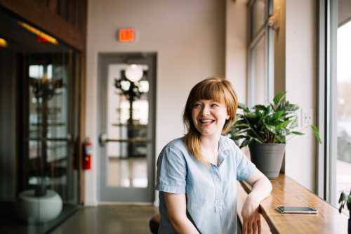 Person smiling sat by a window