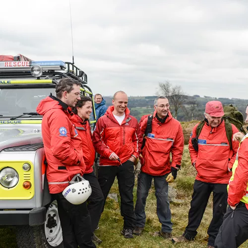 mountain rescue team huddled around van