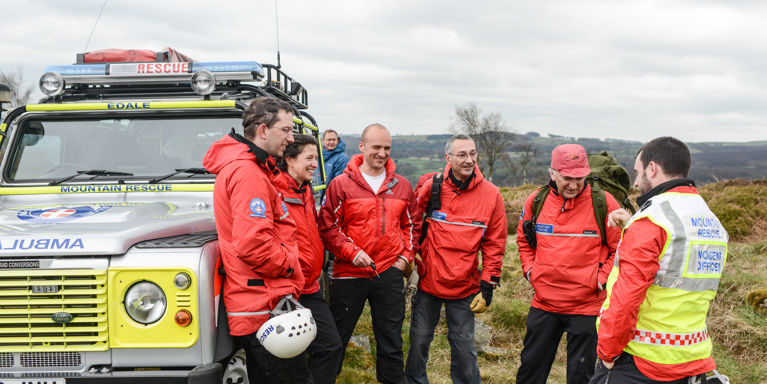 mountain rescue team huddled around van