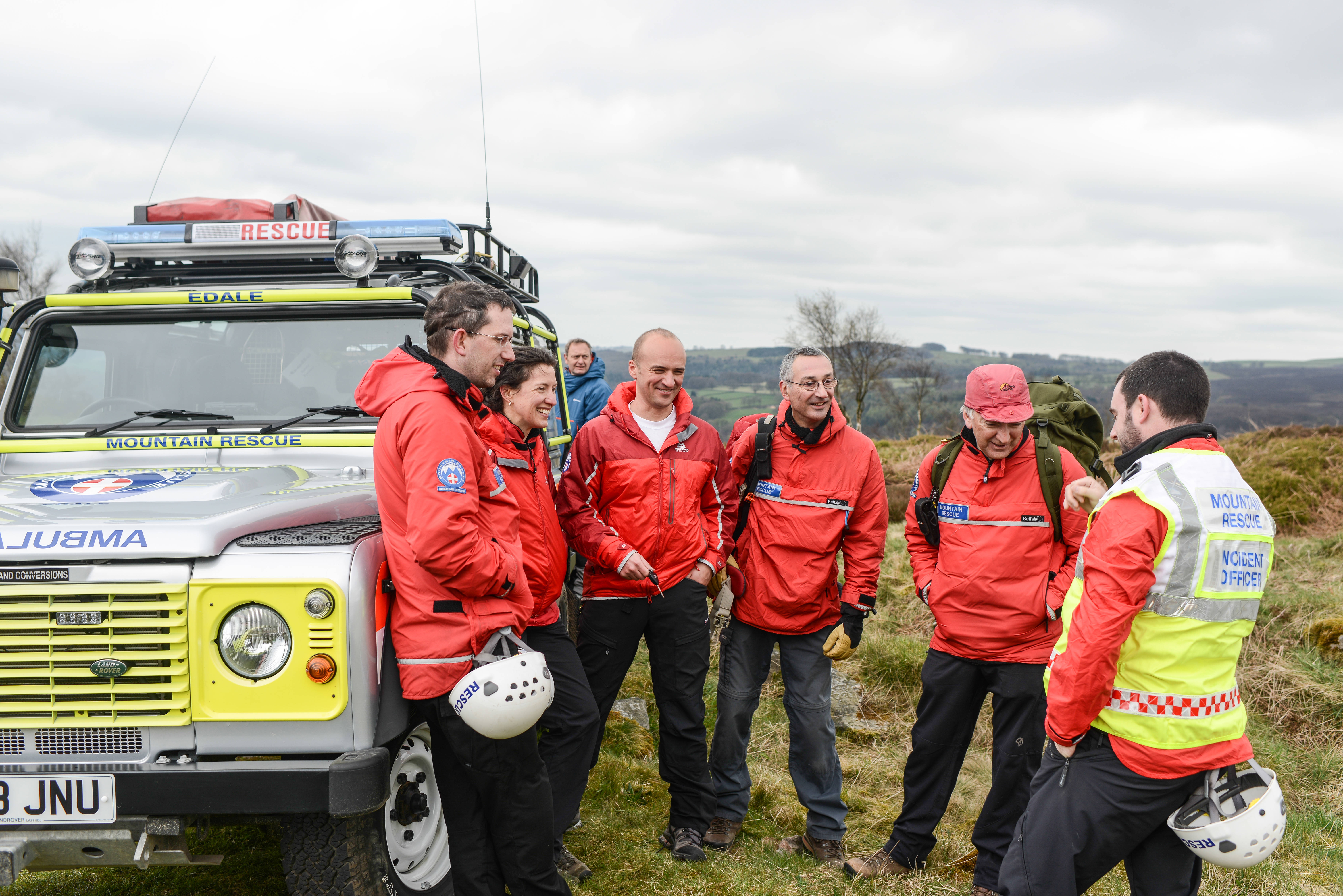 mountain rescue team huddled around van