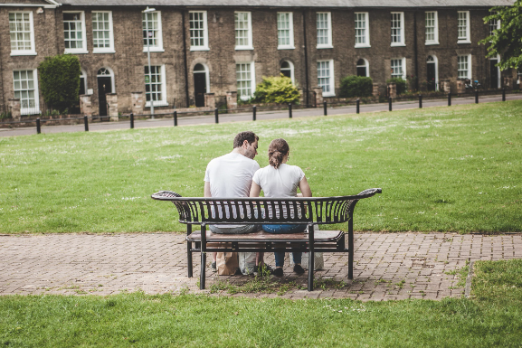 Man and woman sitting on bench in park