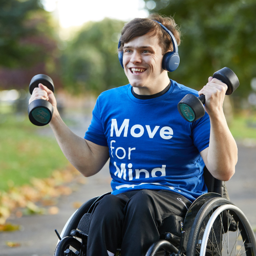 Man in wheelchair lifting weights listening to music