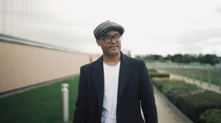 Clarke Carlisle walking outside looking to the right 