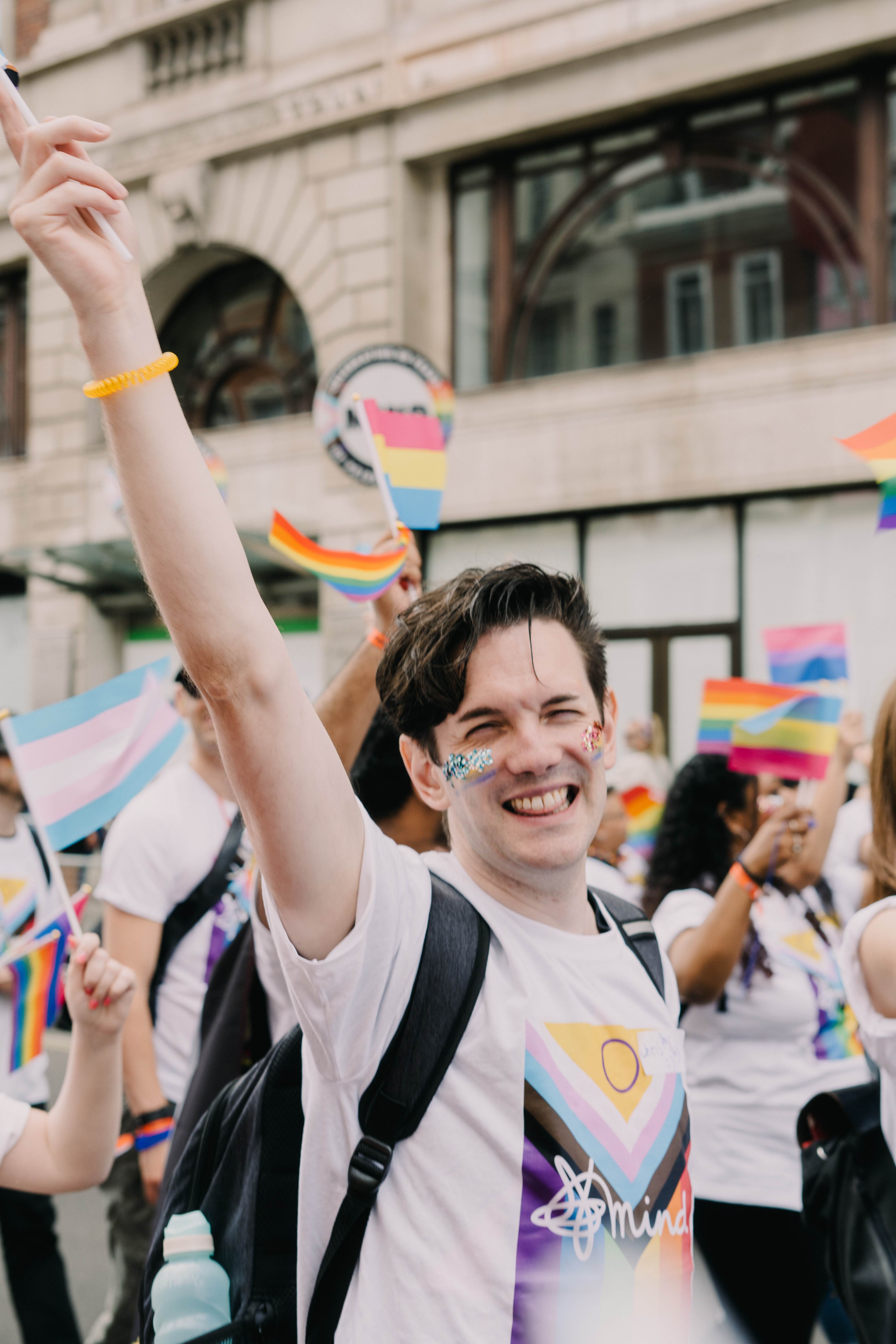 Chris at London Pride march smiling with Mind Pride flag tshirt