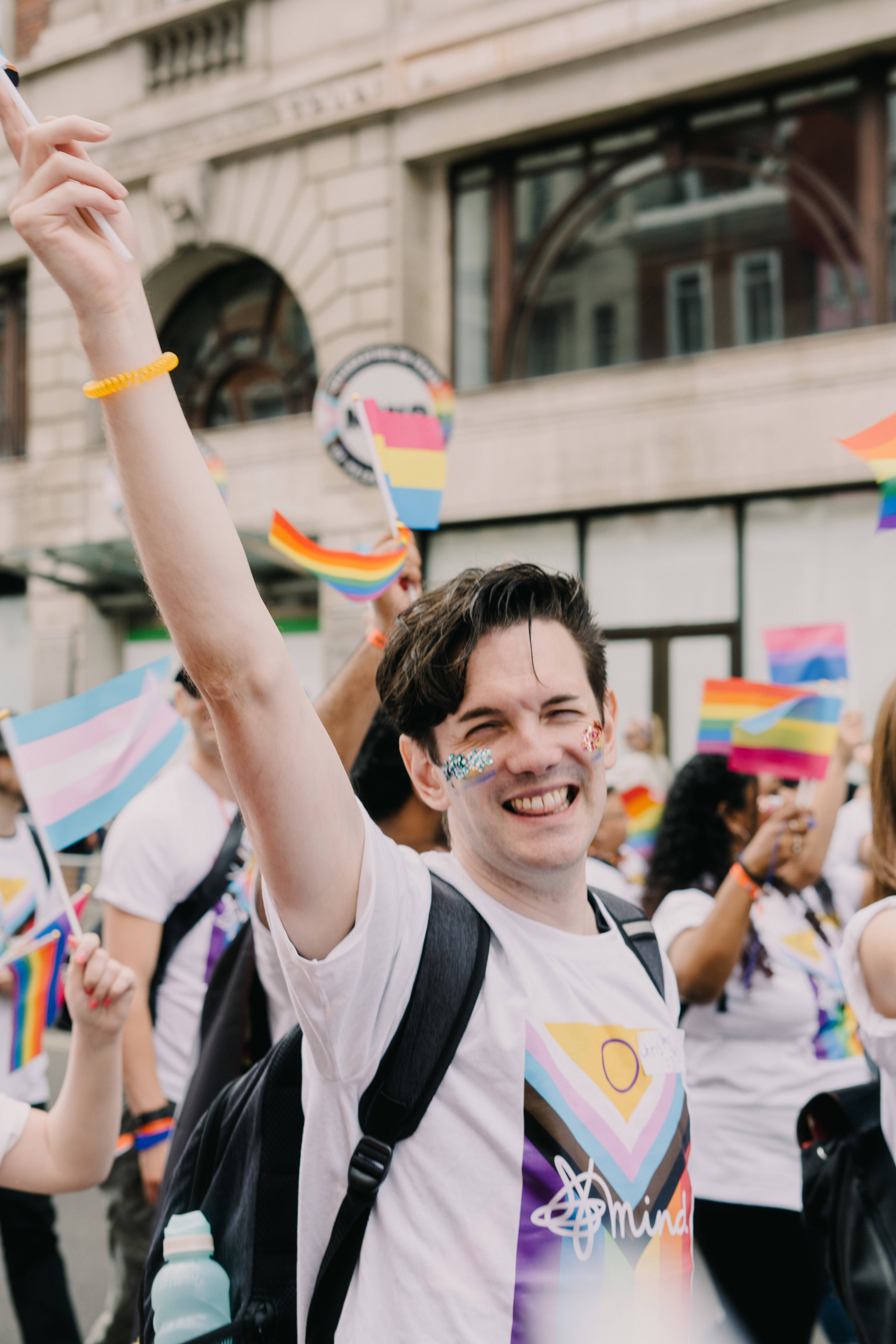 Chris at London Pride march smiling with Mind Pride flag tshirt