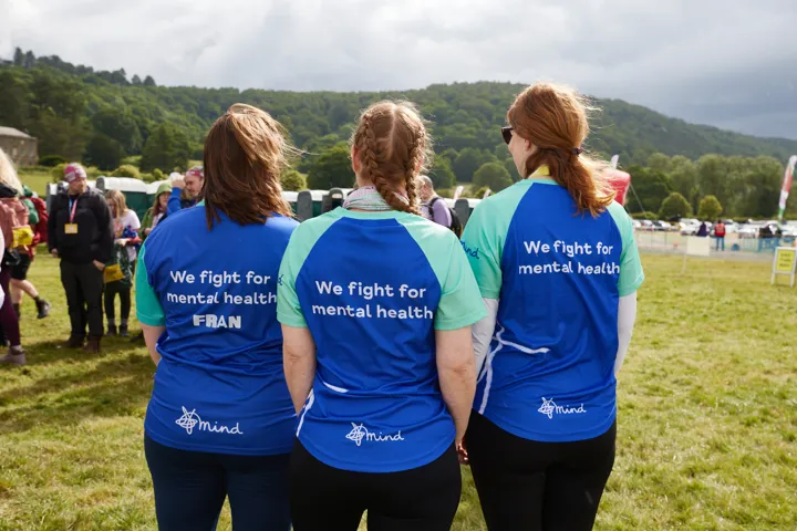 Three woman facing away from the camera, in Mind sports tops.