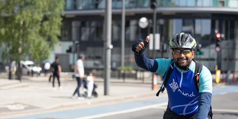 a man cycling in a mind top giving thumbs up
