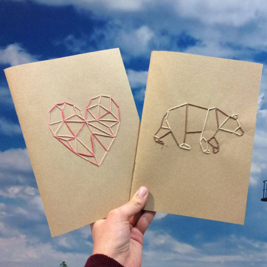Two journals with geometric patterns sewn onto them