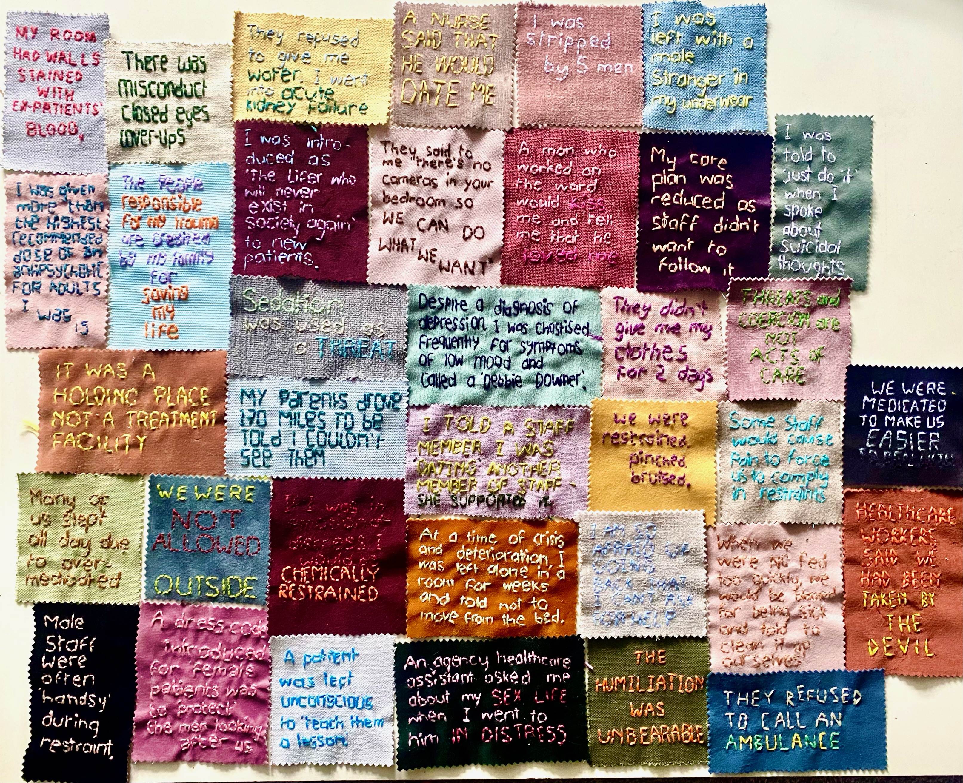 Different coloured fabric squares, embroidered with people's experiences of inpatient mental health care.
