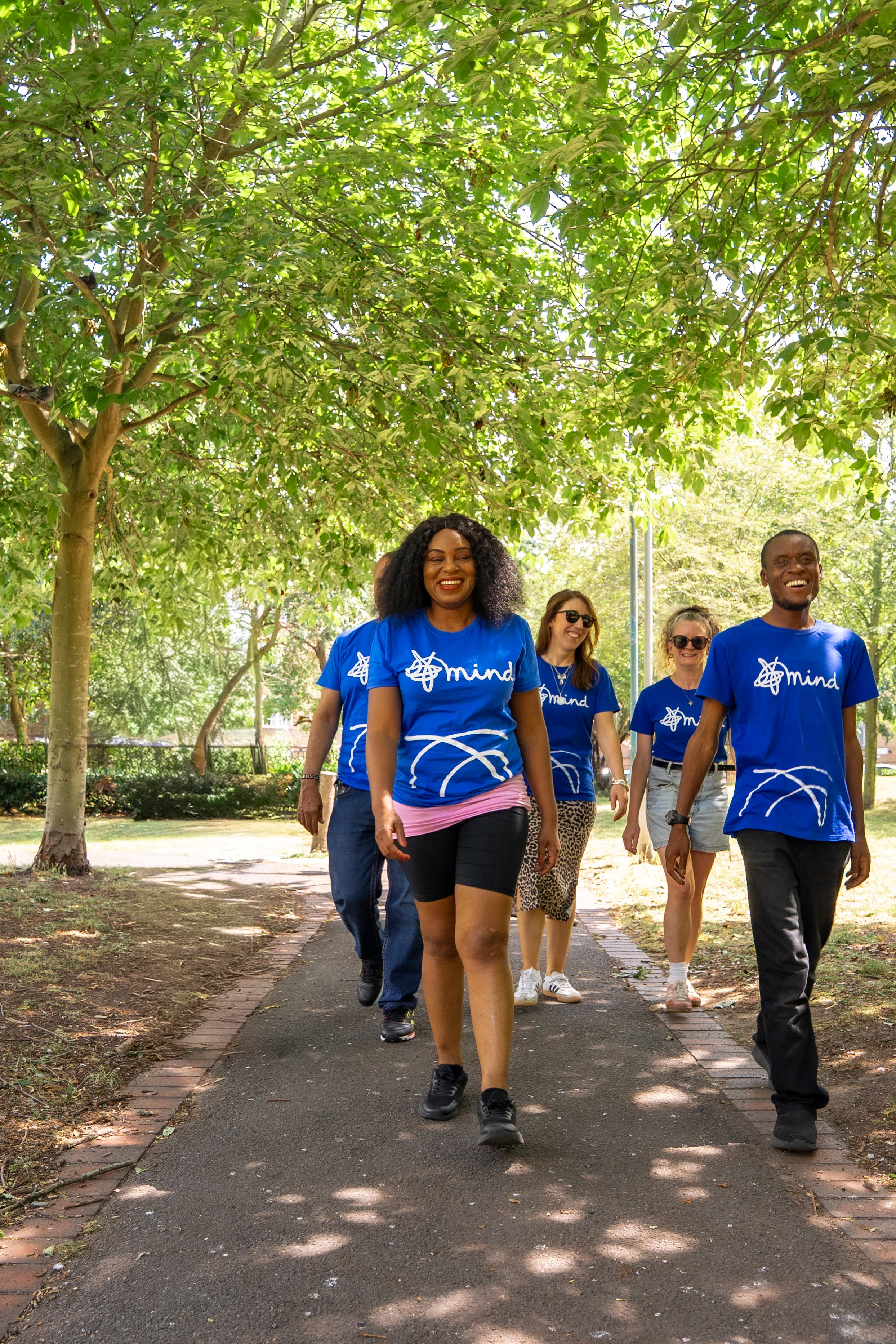 Group of walkers in Mind t-shirts, walking in a park.