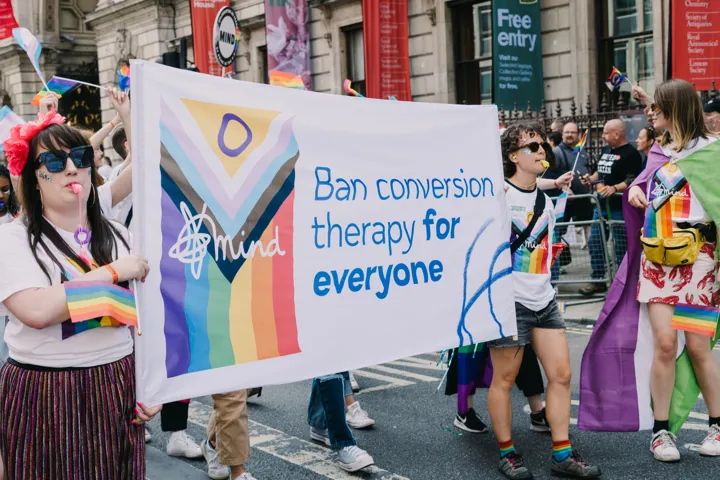 Mind volunteers carrying banner at London Pride saying 'Ban conversion therapy for everyone.' Mind volunteers carrying banner at London Pride saying 'Ban conversion therapy for everyone.'