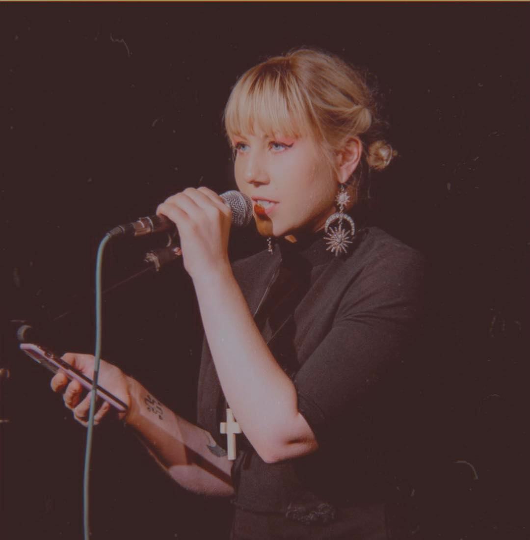 Woman holding and speaking into a microphone