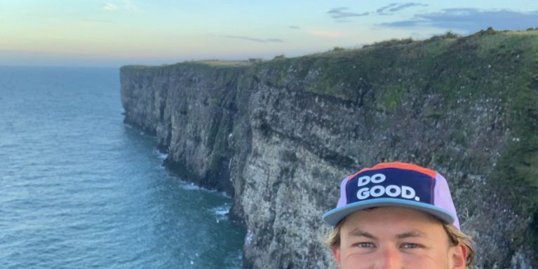 Mind fundraiser James smiling in front of the coast at Aberdeenshire