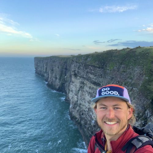 Mind fundraiser James smiling in front of the coast at Aberdeenshire
