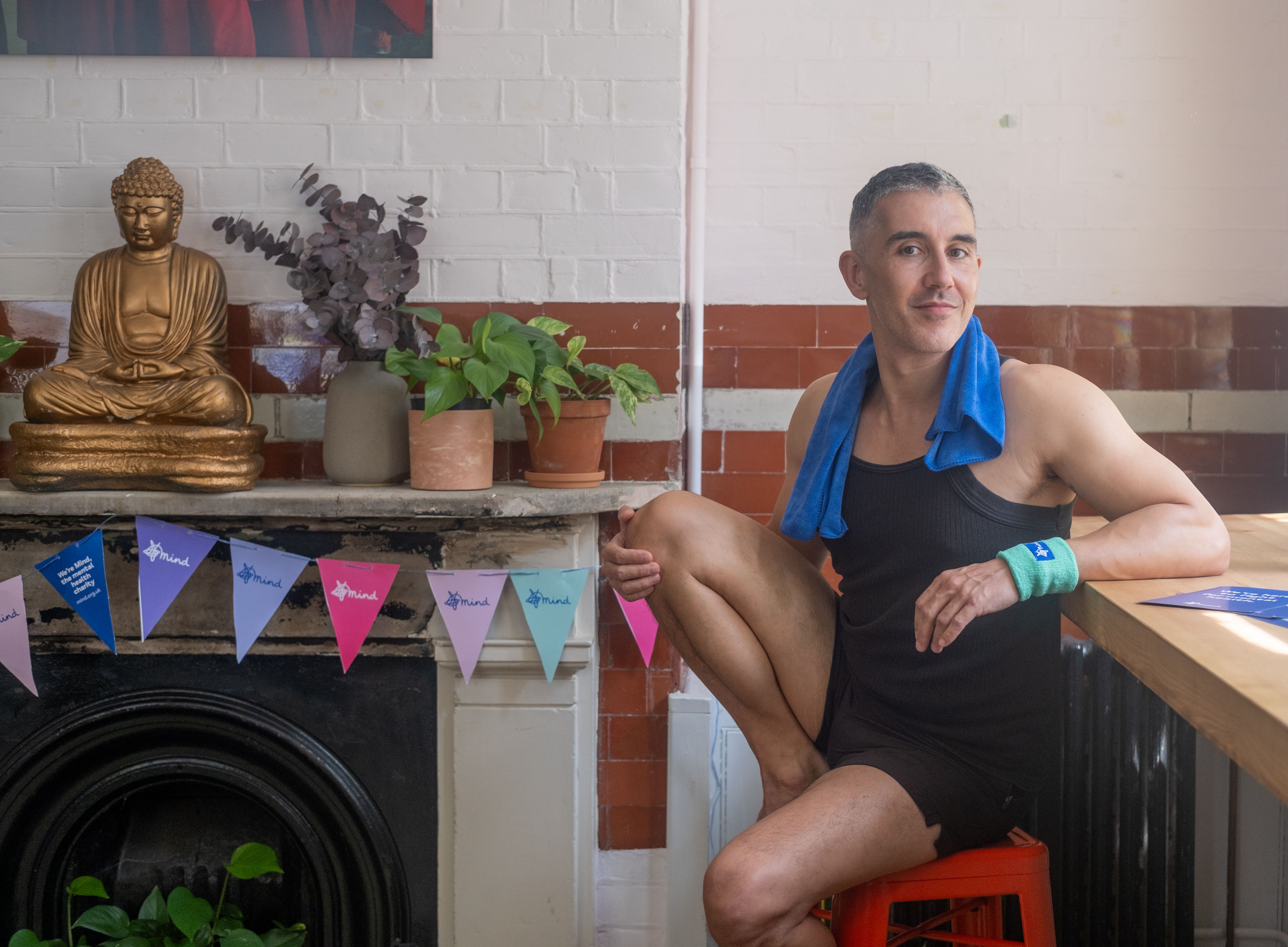 Man sitting at a table in yoga clothes and Mind wristband.