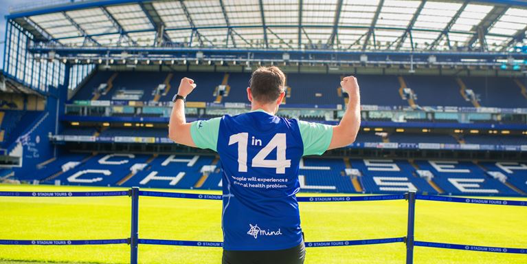 Man stands with his back to Stamford Bridge stadium